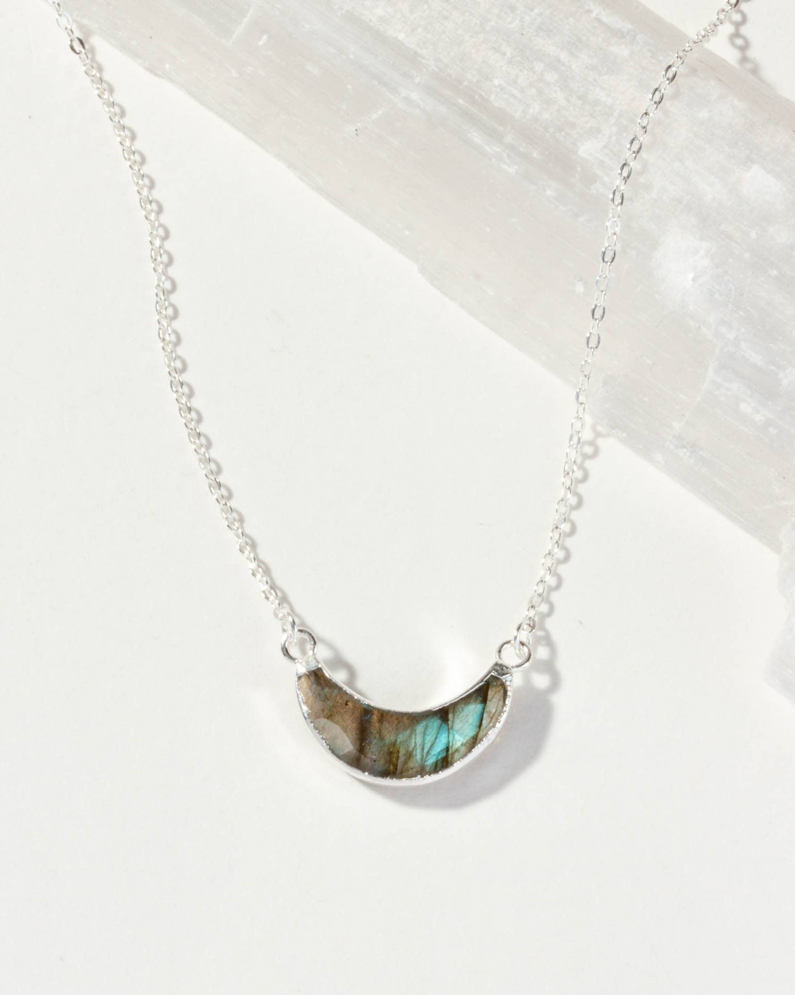 Necklace with a semi-circular Labradorite Eclipse pendant on a white background