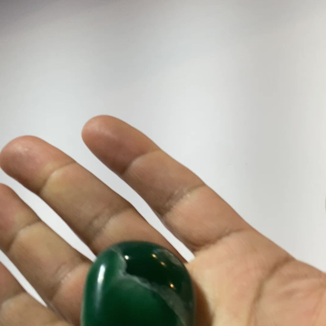 hand holding dark green jade palm stone